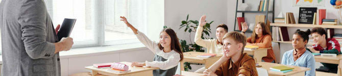 enfants dans une salle de classe levant la main pour répondre à la question de l'instituteur 